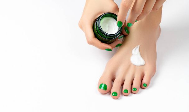 Woman apply cream on feet on white background - Photo, Image