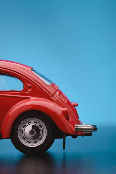 Close up shot of a Partial Backside of a red colored toy model car on a blue background. - Φωτογραφία, εικόνα