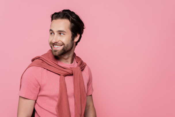 Fröhlicher Mann im T-Shirt blickt vereinzelt auf rosa - Foto, Bild