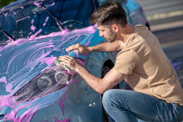 Pozorný muž mytí auta s růžovou pěnou - Fotografie, Obrázek