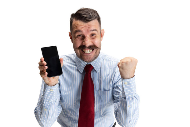 Портрет молодого бизнесмена, офисного работника, менеджера со смартфоном изолирован на белом фоне студии. - Фото, изображение