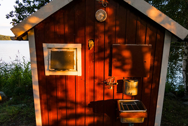Stockholm, Sweden  A little red outhouse with a outdoor sink. - Photo, Image