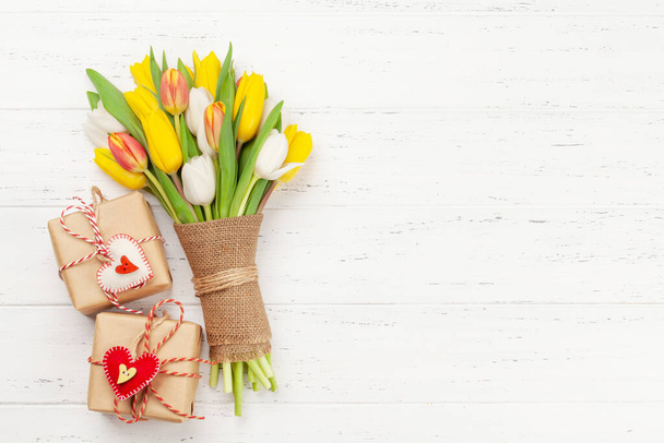 Colorful tulip flowers bouquet and gift boxes with heart shaped decor. Top view flat lay with space for your greetings - Foto, Imagem