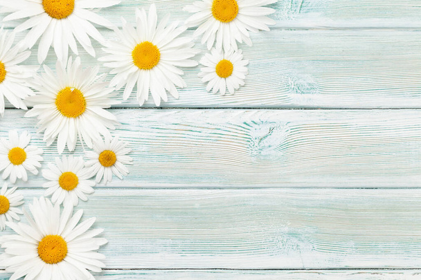 Chamomile flowers background. Garden camomile over wooden backdrop. Top view flat lay with copy space - Foto, afbeelding