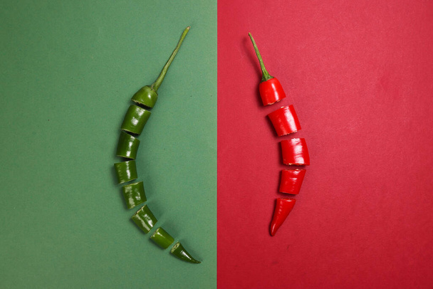 chile rojo verde pimienta sobre papel rojo verde papel cortado piezas semillas - Foto, Imagen