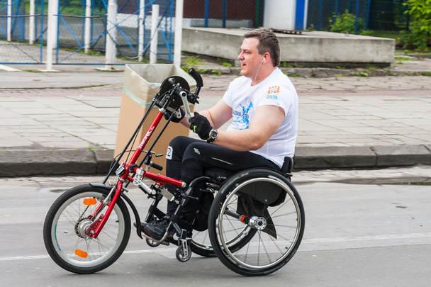 KRAKOW, PUOLA - toukokuu 28: Cracovia Marathon. Tunnistamaton vammainen mies maratonilla pyörätuolissa kaupungin kaduilla 18.5.2014 Krakovassa, PUOLASSA
  - Valokuva, kuva