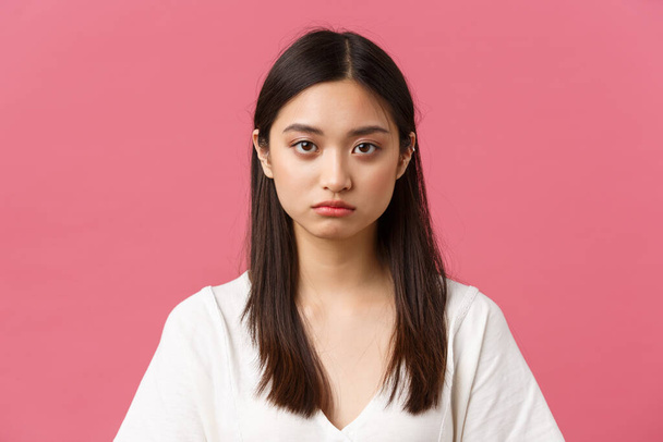Beauty, people emotions and summer leisure concept. Close-up of gloomy and sad, tired young asian female employee looking at camera reluctant, standing distressed over pink background - Photo, Image