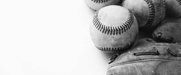 Vecchie palle da baseball con guanto isolato su sfondo bianco accanto attrezzature da gioco sportive. - Foto, immagini