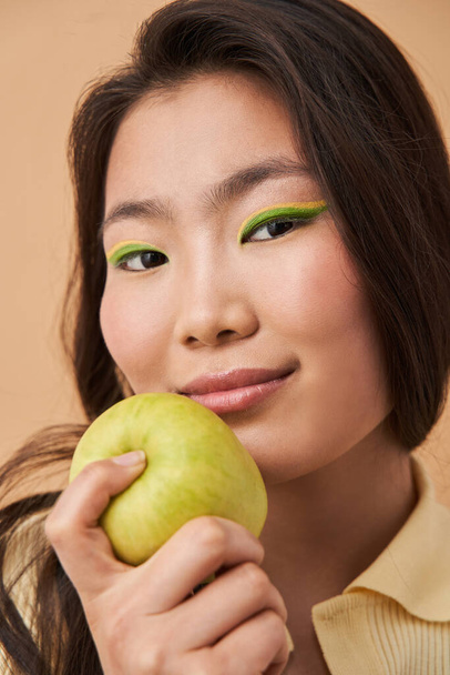 Asian woman with happy face holding apple fruit and smiling - Foto, Imagen