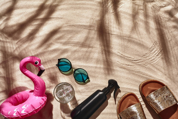 Los accesorios de vacaciones del viajero están dispuestos en una arena de playa blanca. Piso tendido, vista superior. - Foto, Imagen