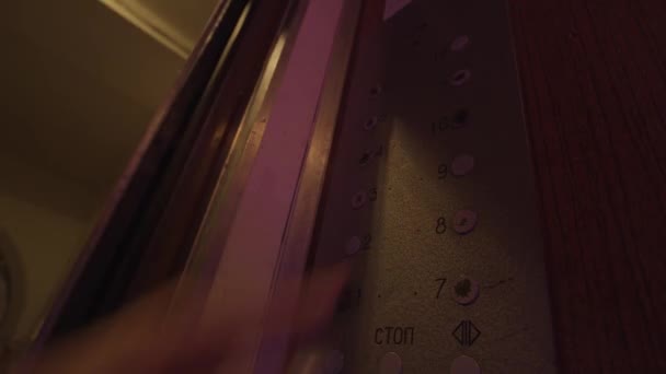 Close-up de uma mão feminina pressiona os botões do elevador. Imagens de stock. Seleção dos 8 e 9 andares dentro de um elevador à moda antiga com luzes coloridas piscando. - Filmagem, Vídeo