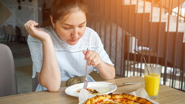 Lady eats pizza enjoying in the restaurant - Foto, imagen