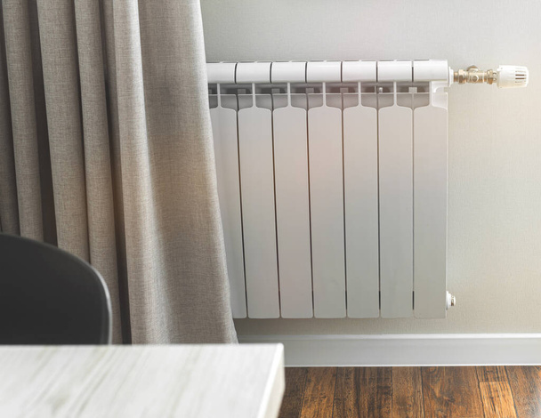 Riscaldamento radiatore in una stanza luminosa con il pavimento in legno laminato - Foto, immagini