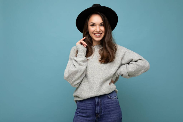 Photo of young positive happy smiling beautiful woman with sincere emotions wearing stylish clothes isolated over background with copy space - Fotó, kép