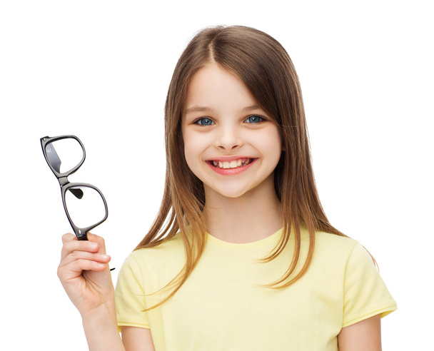 smiling cute little girl holding black eyeglasses - Foto, afbeelding