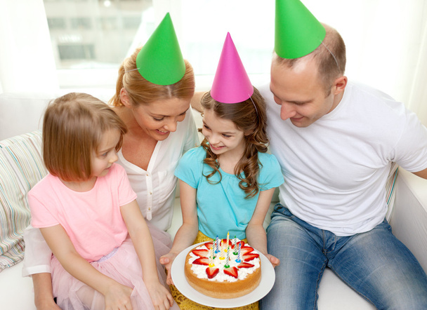 smiling family with two kids in hats with cake - Fotografie, Obrázek