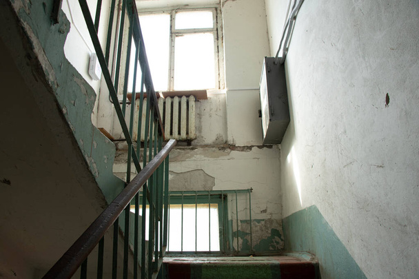 old dirty staircase without repair with a staircase in a residential building in Ukraine, an entrance in a multi-storey building - 写真・画像