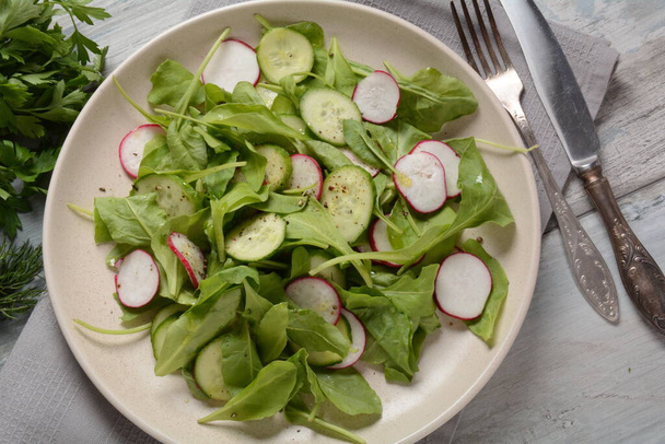 Fresh vegetarian vegetable salad with radish, cucumber and arugula, healthy food. - Photo, image