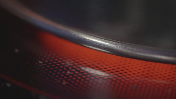 Close up de chaleira de metal inoxidável em um fogão de indução elétrica. Acção. Cozinhar, hora do café da manhã, água fervente em uma chaleira de aço em um fogão quente vermelho. - Filmagem, Vídeo
