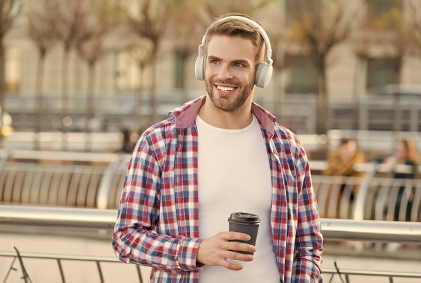 handsome young man wear headphones and smiling while listening music and drinking coffee, morning inspiration. - Foto, Imagem