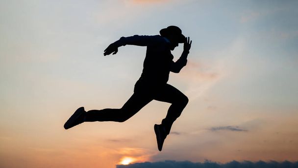 silhouette of man running in sense of freedom on sunrise sky, stamina - Zdjęcie, obraz