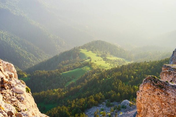 Wielki Thach na Kaukazie. Widok ze szczytu góry przez skały do zielonej łąki i drzew iglastych. Wysokiej jakości zdjęcie - Zdjęcie, obraz