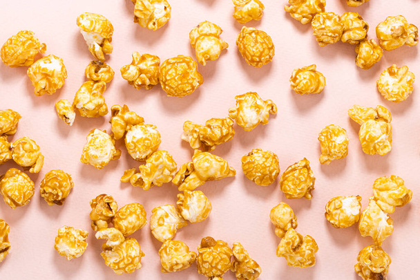 Karamell-Popcorn auf pastellrosa Hintergrund. - Foto, Bild