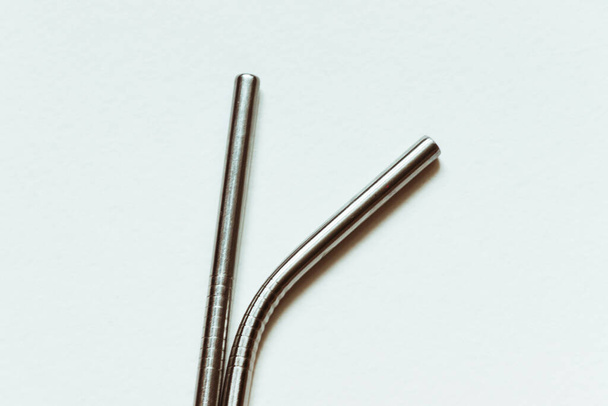 Two straws for drinks from stainless steel lie on a white background. - Photo, Image
