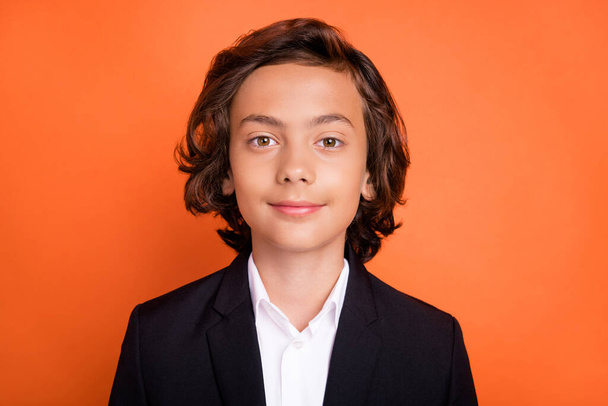 Photo of young brunette calm peaceful boy wear formalwear suit uniform isolated on orange color background - Photo, Image
