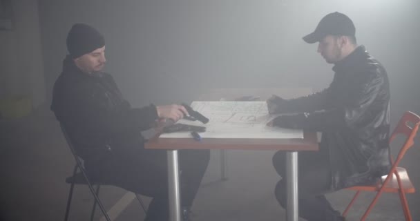 Two criminals planning a bank job together in the smokey garage - Footage, Video