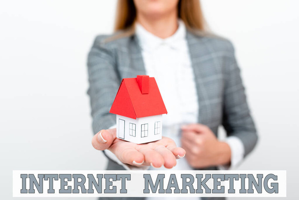 Text caption presenting Internet Marketing. Conceptual photo drive direct sales of products via electronic commerce A Young Lady Orbusinesswoman Holding Orpresenting Home In Business Outfit - 写真・画像