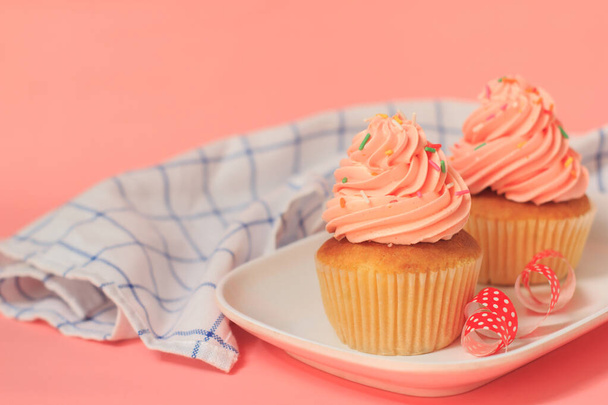 Heerlijke roze cupcakes op een roze achtergrond - Foto, afbeelding