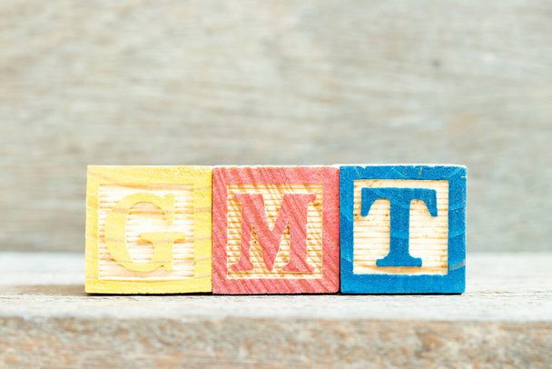 Bloc alphabet couleur lettre en mot GMT (abréviation de Greenwich Mean Time) sur fond bois - Photo, image