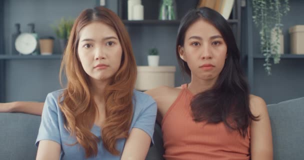 Two Asia lesbian women site on couch angry not talk after dispute upset with each other in living room at home. Ladies unhappy after argument looking away from each other, Bad relationship concept. - Footage, Video