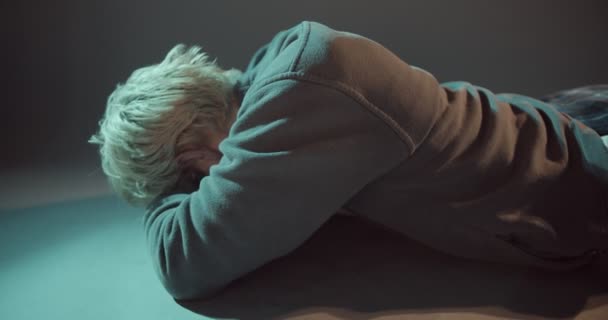 Nuori poika makaa ja yrittää olla itkemättä kipua hänen sisällään - Materiaali, video