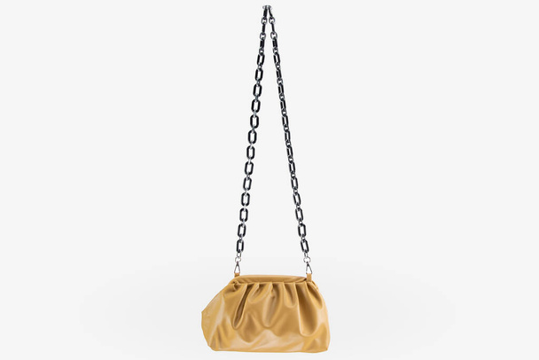 A Women handbag hanging against white background. Beautiful luxurious bright red leather handbag front view, without shadow on white background.Handbag isolated hangs on golden chains - Photo, Image