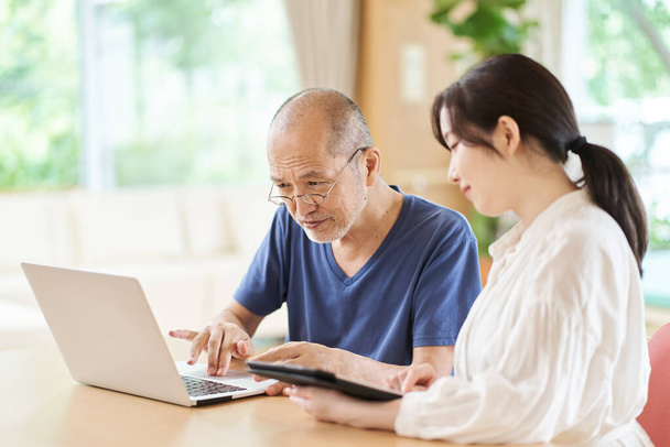 Пожилые люди, которых учат пользоваться компьютером в учреждении длительного ухода - Фото, изображение