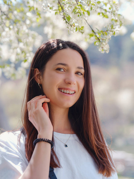 Young smiling brunette woman outdoors portrait. sunny spring or summer day in nature - Zdjęcie, obraz