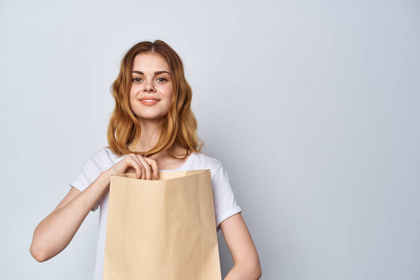 woman with paper bag in her hands Shopping fun light background - Φωτογραφία, εικόνα