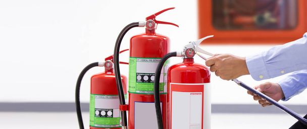 Technika pożarnicza sprawdzanie poziomu ciśnieniomierza w zbiornikach gaśnic w koncepcjach ochrony budynków oraz zapobieganie awaryjnemu i bezpieczeństwu szkolenia ratowniczego i przeciwpożarowego. - Zdjęcie, obraz