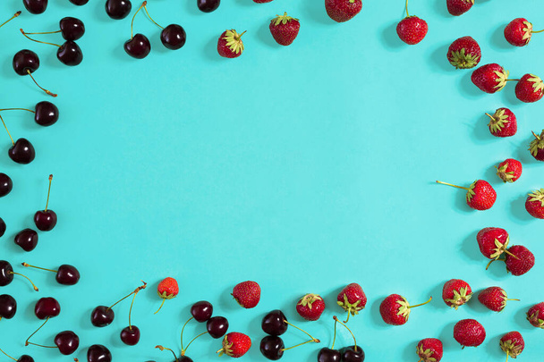 Strawberry and cherries on a blue background - Zdjęcie, obraz