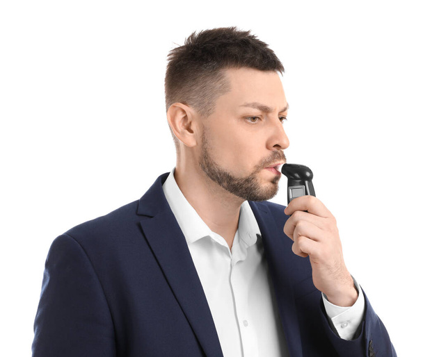 Man blowing into breathalyzer on white background - 写真・画像
