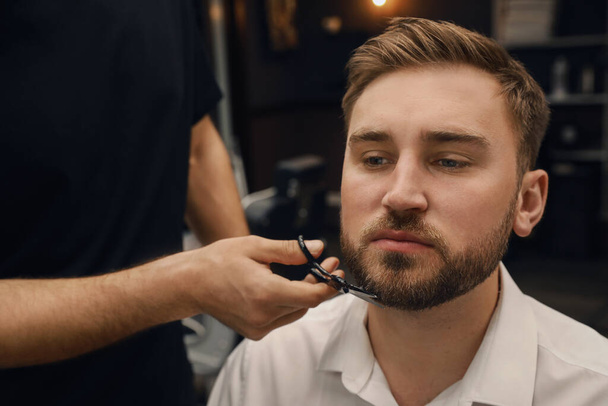 Professional hairdresser working with client in barbershop - Photo, image