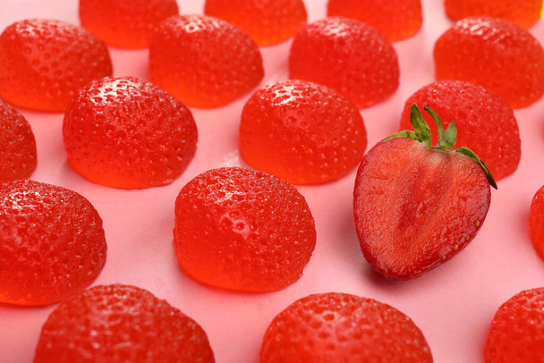 Delicious gummy candies and fresh strawberry on pink background, closeup - Foto, Bild