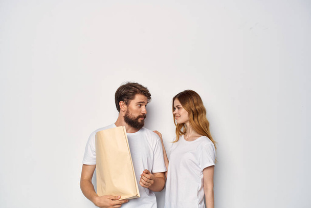 άνδρας και γυναίκα σε λευκό t-shirt μόδας τσάντες shopping χαρτί μόδας - Φωτογραφία, εικόνα