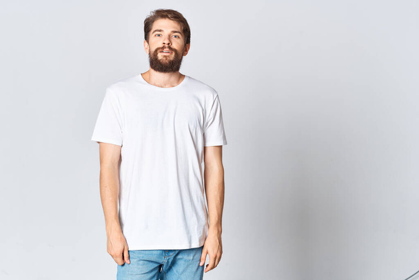 barbudo hombre en blanco camiseta y jeans copia espacio maqueta posando - Foto, Imagen