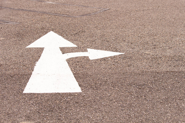 A two way arrow symbol on a black asphalt road surface. - Foto, Imagem