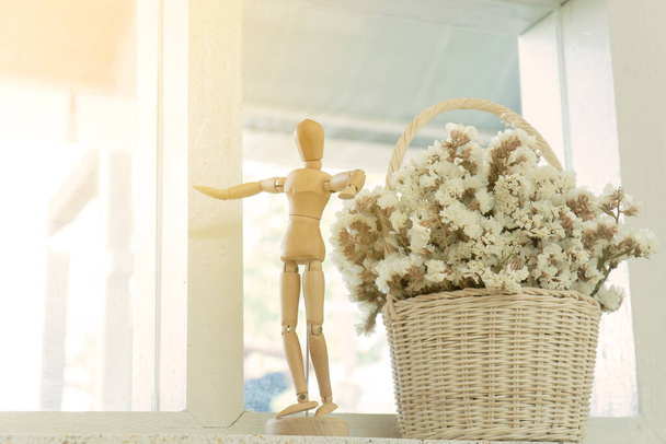 Marioneta de madera y maceta en cafetería. Flores secas en un jarrón. - Foto, Imagen