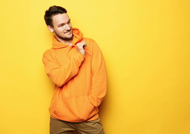 young man posing over yellow background, casual style - Φωτογραφία, εικόνα