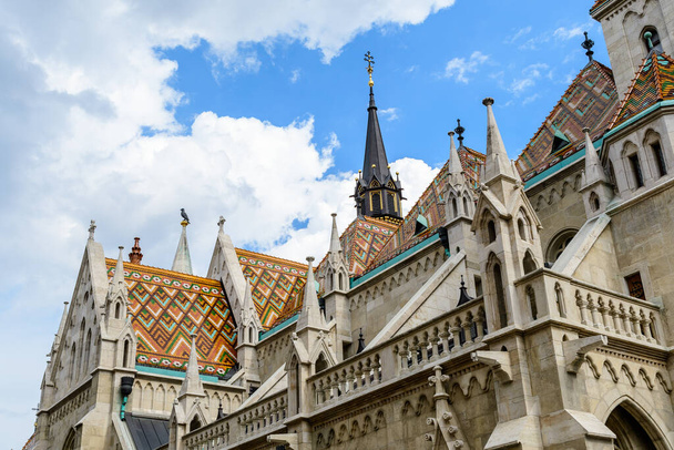 Details of the Matthias Church that is a Roman Catholic church located in Budapest, Hungary, in front of the Fisherman's Bastion at the heart of Buda's Castle District, in a sunny day - Foto, Imagem